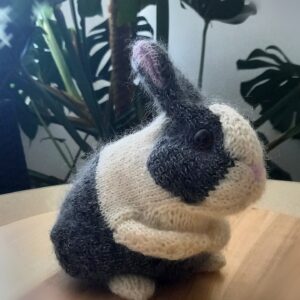 Handgestricktes grau-weißes Häschen, Seitenansicht