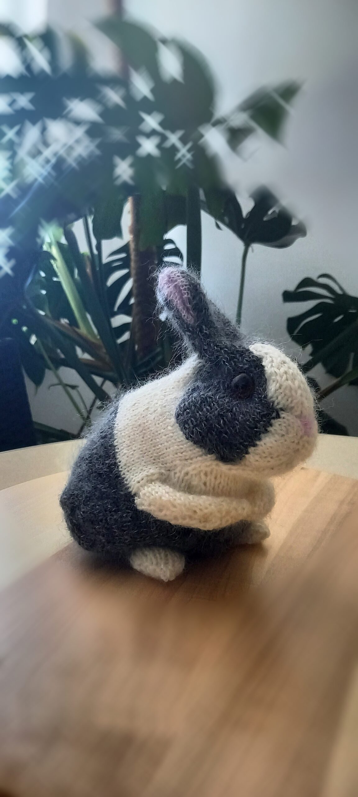 Handgestricktes grau-weißes Häschen, Seitenansicht
