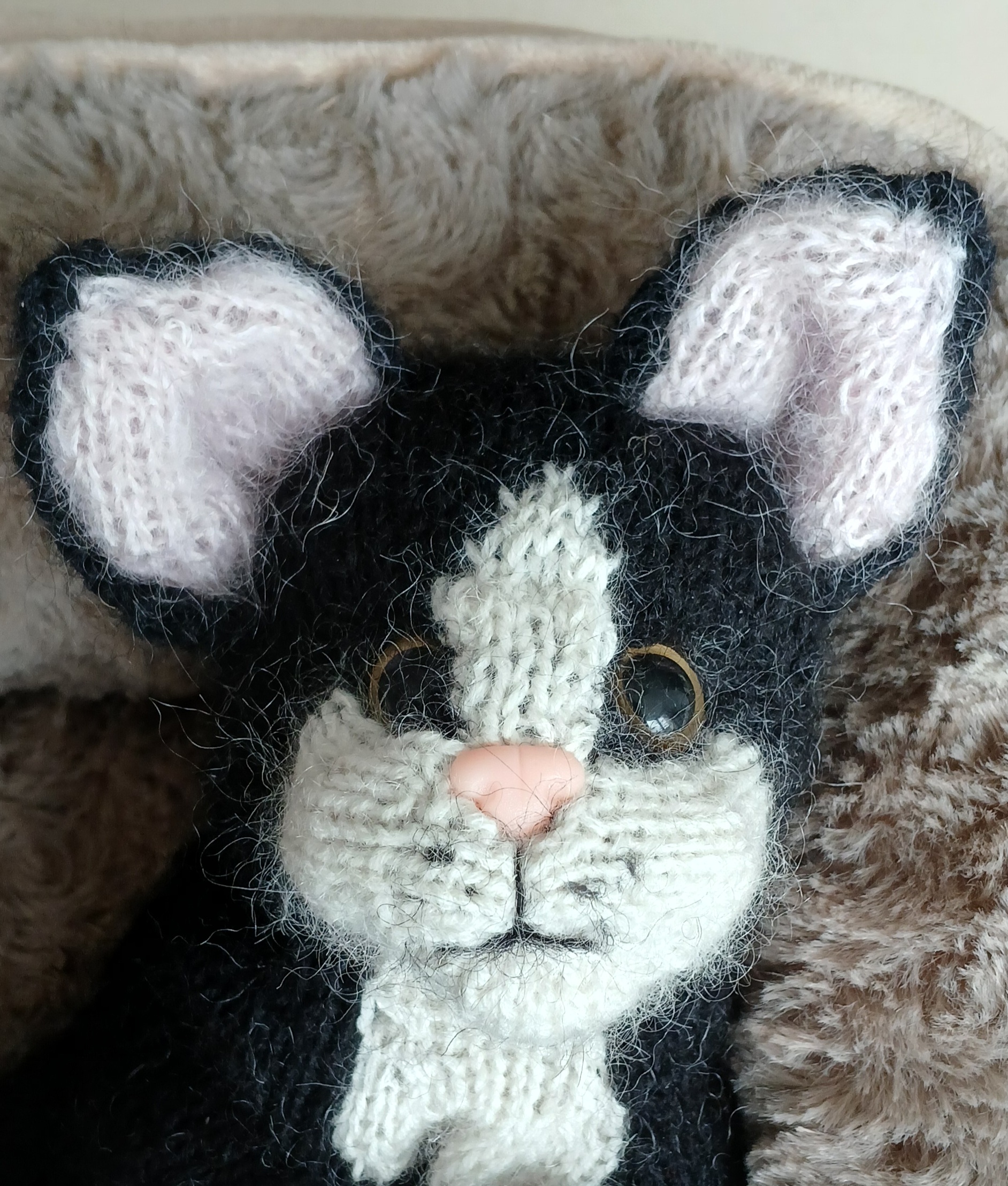 Gesicht einer handgestrickten Katze mit aufgestickten Details