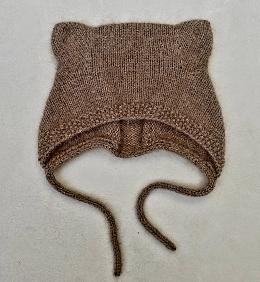 Handgestrickte Teddyhaube aus Merino – passend zum festlichen Taufoutfit